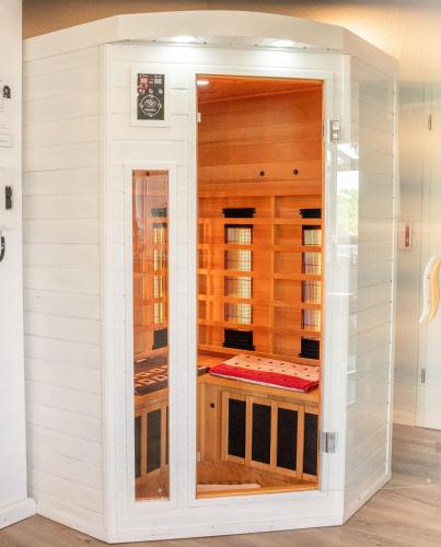 a sauna with a glass door in a room at SmartFewo Loft Sauna Balkon Parkplatz in Bad Zwischenahn