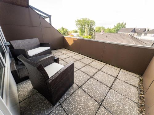 a patio with two chairs and tables on a balcony at SmartFewo Loft Sauna Balkon Parkplatz in Bad Zwischenahn
