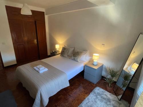 a bedroom with a white bed and two lamps at Quarto Alameda in Lisbon