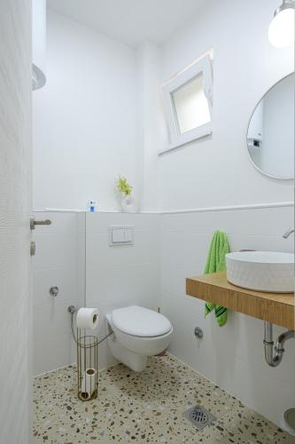 a white bathroom with a toilet and a sink at Piramida Visoko in Visoko