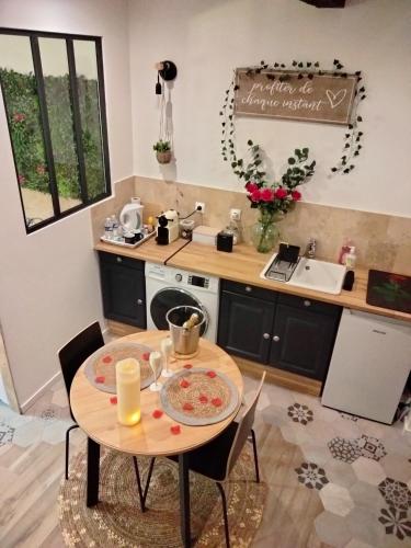 une petite cuisine avec une table et un évier dans l'établissement Maison Prestige Le Donjon des Plaisirs Jacuzzi, à Montluel