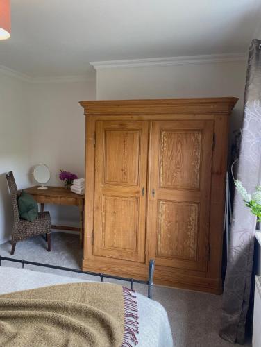 a bedroom with a wooden cabinet and a desk at Shanakeever Farm - 3 Bedroom Apartment in Clifden