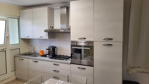 una cucina con mobili bianchi e una stufa di ilgecotds a Torino di Sangro