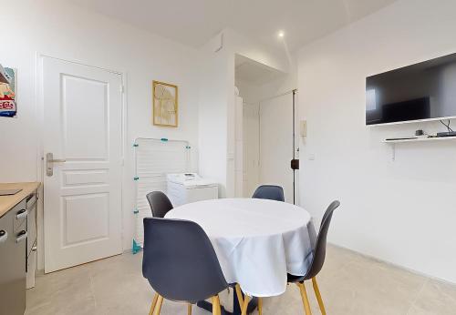 une table et des chaises blanches dans une pièce blanche dans l'établissement Magnifique appartement 3Pièces Paris Expo Pte de Versailles, à Vanves