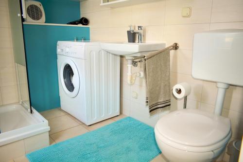 a bathroom with a washing machine and a sink at Ferienwohnung am See in Heldrungen
