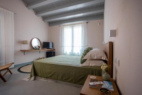 a bedroom with a bed and a window and a table at Planeta Country House & Beach Club in Menfi