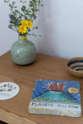 a table with a vase of flowers and a book at Planeta Country House & Beach Club in Menfi