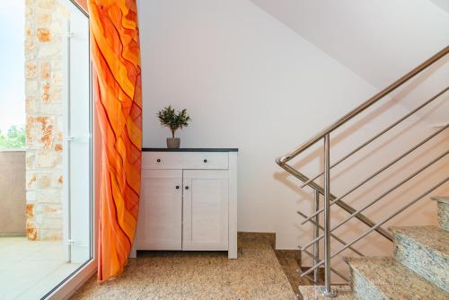 a staircase in a home with an orange curtain at Private Villa SoulSet with swimming pool in Vantačići