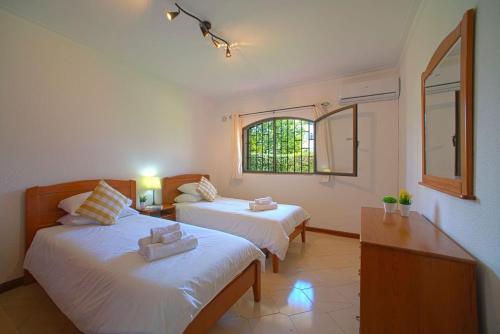 1 Schlafzimmer mit 2 Betten und einem Fenster in der Unterkunft 2 Bed Ground Floor Apartment In Vilamoura in Vilamoura