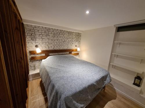 une chambre avec un lit et un mur de briques dans l'établissement 2 Adorables appartements proches de Paris et Disneyland, à Villiers-sur-Marne