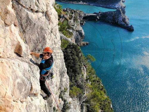 a man is climbing a mountain with a camera at La Mansarda sul Golfo in Portovenere