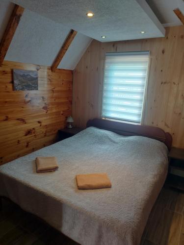 a bedroom with a bed with two towels on it at Durmitor Bungalows in Žabljak