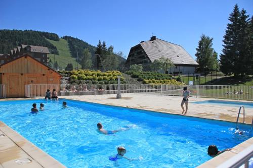 a group of people swimming in a swimming pool at Studio 4 personnes, pied des pistes ski et VTT in Métabief