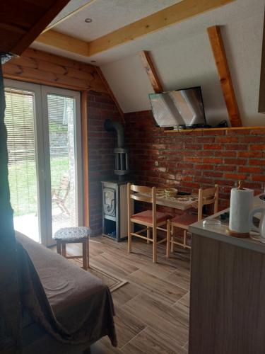 eine Küche und ein Wohnzimmer mit einer Ziegelwand in der Unterkunft Durmitor Bungalows in Žabljak