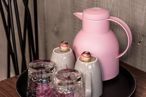a pink jug and some glasses on a plate at Senses Violett Suites - Adults Only in Zell am See