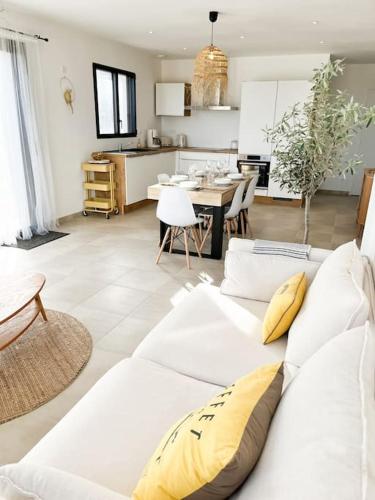 un salon avec un canapé blanc et une cuisine dans l'établissement Villa Molène jacuzzi et plage à 500 m, à Tréveneuc