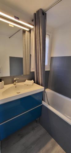 une salle de bain avec un lavabo, un miroir et une baignoire dans l'établissement Appartement en résidence avec piscine, à Bandol