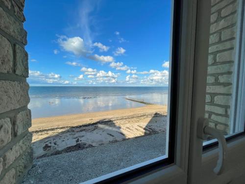 a view of the beach from a window at Le Clos Normand in Saint-Aubin-sur-Mer