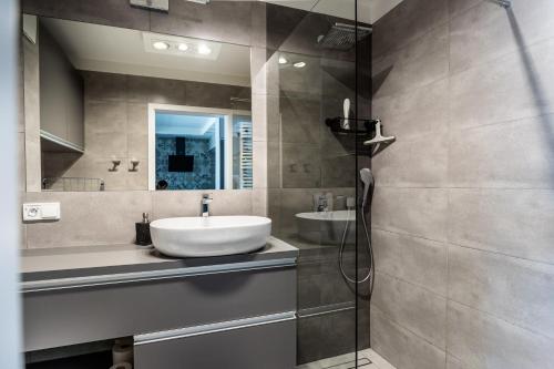 une salle de bain avec un lavabo et un miroir dans l'établissement Apartament Batorego 7 z parkingiem, à Gdynia