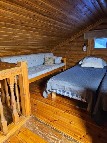 a bedroom with a bed in a log cabin at Koivurannan Lomamökit Mänty in Nykälä