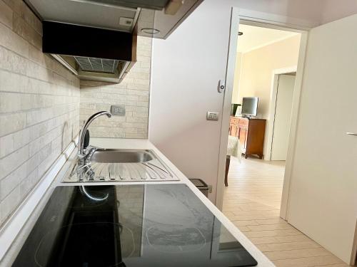 una cucina con un lavello e un piano di lavoro di Donizetti Vacation Apartment a Porto Cesareo