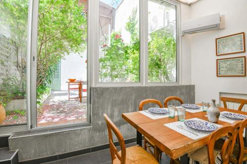 une salle à manger avec une table, des chaises et des fenêtres dans l'établissement L'Atypique - Appart 2 ch avec terrasse et clim, à Marseille