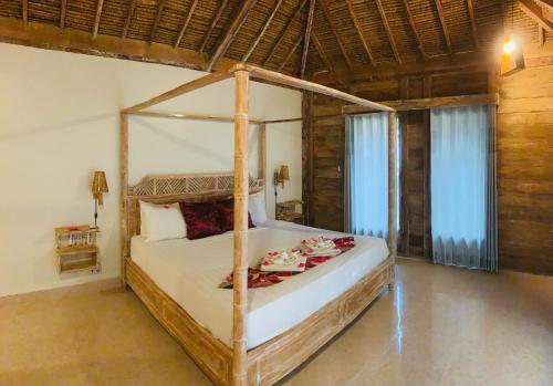 a bedroom with a canopy bed in a room at Alwi Villa Gili Trawangan in Gili Trawangan