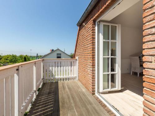 a balcony with a window and a brick building at Giselas Ferienwohnung Ostsee in Holzstein in Oldenburg in Holstein