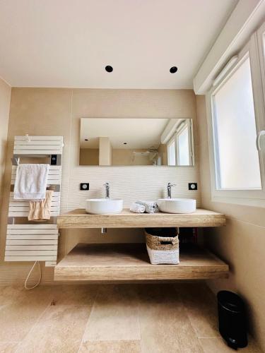 une salle de bain avec deux lavabos et un grand miroir dans l'établissement BENEDETU, à Porto-Vecchio