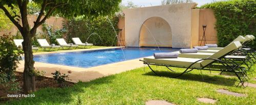 a swimming pool with lounge chairs next to a pool at Villa Ayada in Marrakech