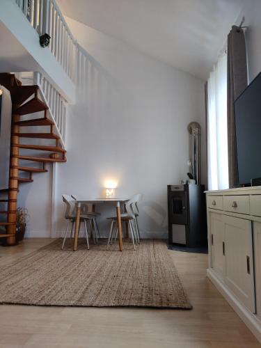 un salon avec une table et un escalier dans l'établissement Au Saule Pleureur, à Villers-Saint-Paul