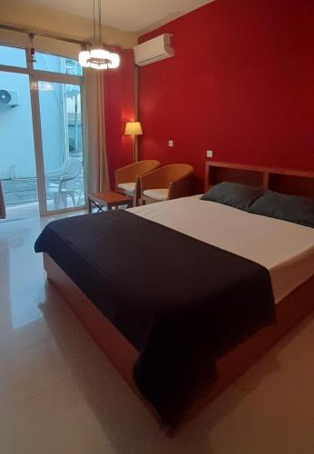a bedroom with a large bed and a red wall at Coco Lux Studio Grand Baie in Grand Baie