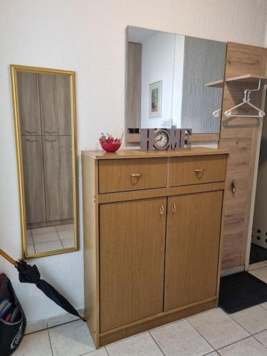 a kitchen with a mirror and a wooden cabinet at Studio apartman Milla in Karlovac