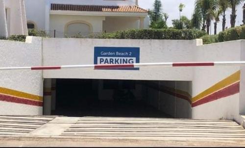 a parking garage with a parking sign in front of a building at Garden Beach 2 sidi rahal in Sidi Rahal