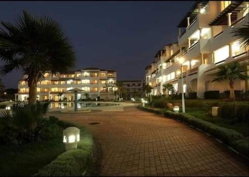 a walkway in front of a building at night at Garden Beach 2 sidi rahal in Sidi Rahal