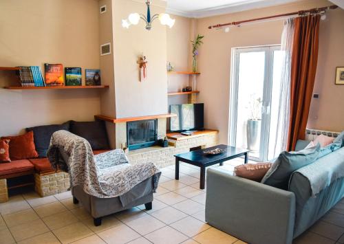 a living room with a couch and a tv at Spacious & Bright flat with balcony in Lávrion