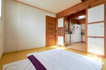 a room with a bed and a large window at Inwoo Guesthouse in Seoul