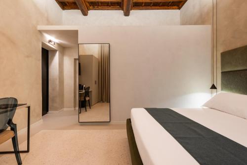 a bedroom with a bed and a mirror at Palazzo Olivia in Rome