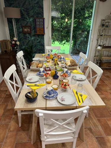 een houten tafel met borden met eten erop bij la villa provençale in La Motte-Chalançon