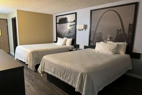 a hotel room with two beds and an arch picture at Super 8 by Wyndham Sullivan in Sullivan