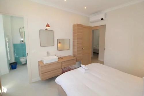 une chambre avec un lit, un lavabo et un miroir dans l'établissement Maison Carnot, à Cannes