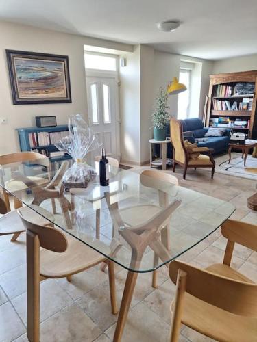 - une table et des chaises en verre dans le salon dans l'établissement Maison familiale bretonne à 2 pas de la mer et des commerces, à Carantec