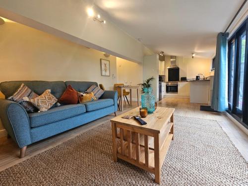 a living room with a blue couch and a table at Lilys Cottage Mendlesham Green Stowmarket Suffolk in Stowmarket