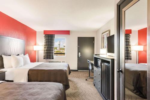 Clarion Inn & Suites Russellville I-40 في روسيلفيل: غرفة فندقية بسريرين وتلفزيون بشاشة مسطحة