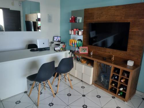 uma cozinha com duas cadeiras e um balcão com uma televisão em Pousada Sol & Mar em Ubatuba