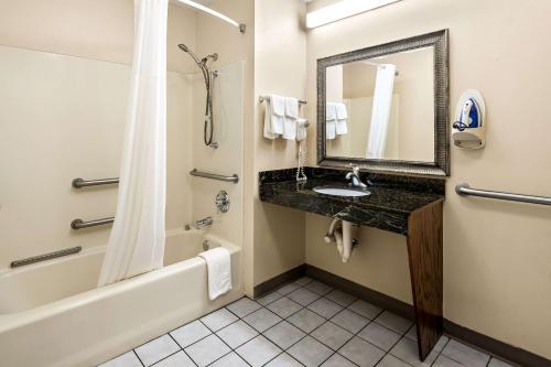 a bathroom with a sink and a tub and a mirror at Quality Inn Decatur River City in Decatur