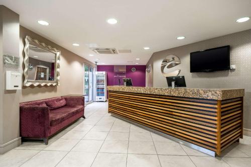 a lobby with a bar with a tv and a couch at Clarion Hotel Newcastle South in Sunderland