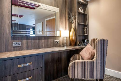 a living room with a mirror and a chair at Holiday Inn Newcastle South by IHG in Boldon