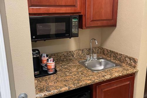 a kitchen counter with a sink and a microwave at Comfort Inn Indianapolis South I-65 in Indianapolis