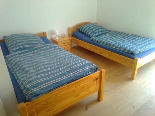 two twin beds in a room with blue sheets at FeWoMeißner in Wittingen